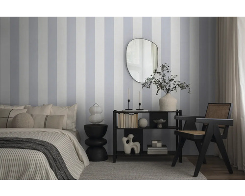 Slaapkamer met bed, dressoir, spiegel en gestreept behang