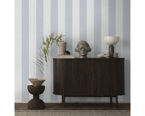 Woonkamer met gestreept behang, dressoir en decoraties.