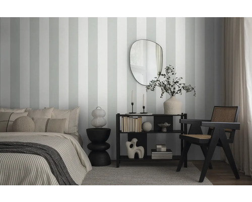 Slaapkamer met gestreept behang, bed, spiegel en plank