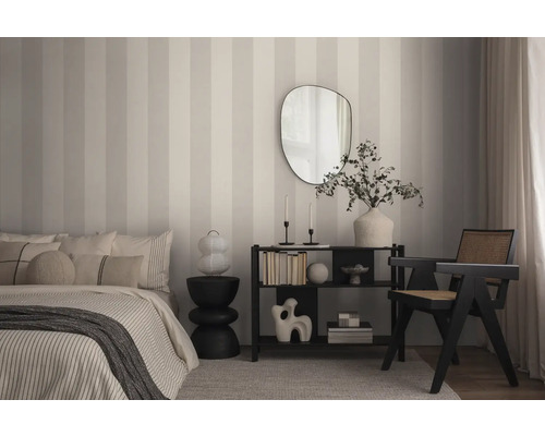 Slaapkamer met bed, rek, spiegel en stoel voor gestreept behang