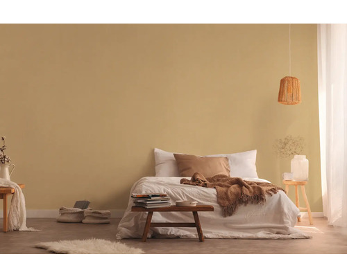 Slaapkamer met bed, nachtkastje en decoratieve elementen voor een gezellige sfeer.