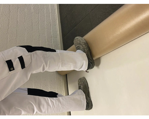 Schilder in werkkleding en verf op een muur