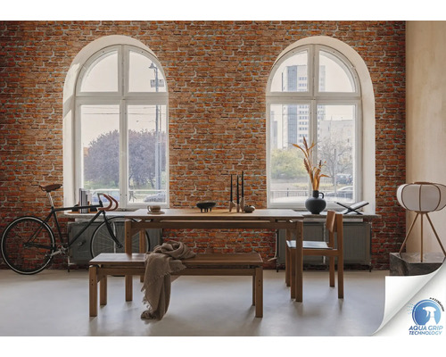 Woonkamer met bakstenen muur, eettafelgroep, fiets en twee boogvensters