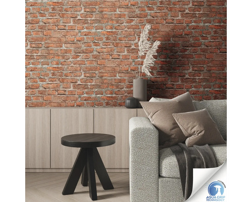 Woonkamer met bakstenen muur, bank, tafel en dressoir