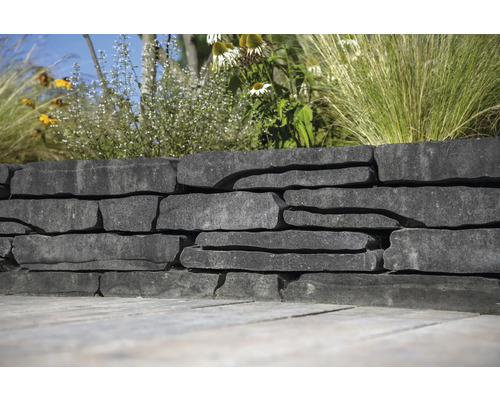 Natuurstenen muur met beplanting in de tuin