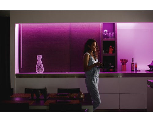 Vrouw met borden in een moderne keuken met decoratieve verlichting