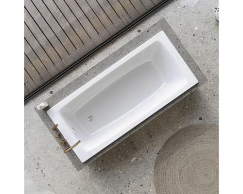 Rechthoekig bad in een badkamer met houten wand en tegelvloer