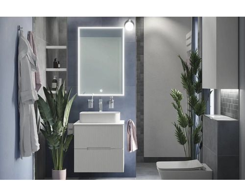 Moderne badkamer met wastafel, spiegel met verlichting en toilet.