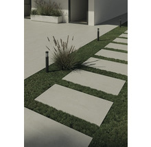 Tuin met stenen loopplaten, gazon en decoratieve lampen