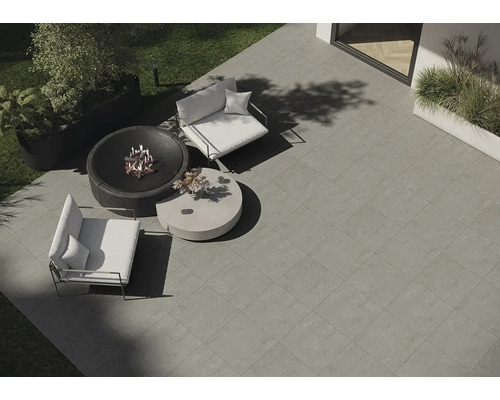 Tuin met stenen tegels, vuurplaats, fauteuils en tafel