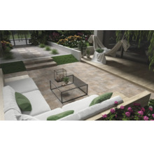 Terras met stenen tegels, tuinmeubelen en beplanting voor een ontspannen buitenruimte.