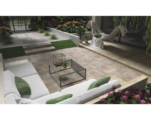 Terras met stenen tegels, tuinmeubelen en beplanting voor een ontspannen buitenruimte.