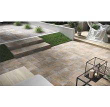 Terras met stenen tegels en trap in de tuin