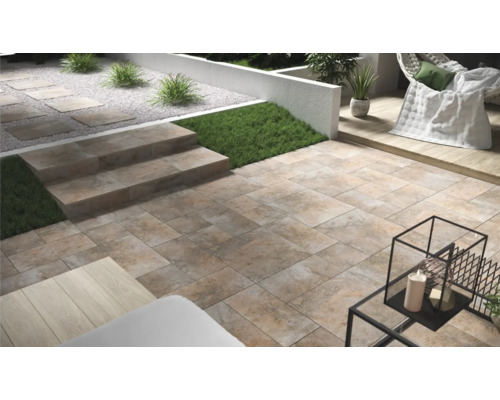 Terras met stenen tegels en trap in de tuin