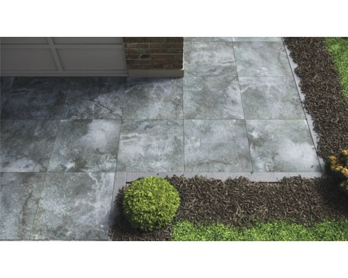 Tuinpad met grijze stenen platen, grind en groen