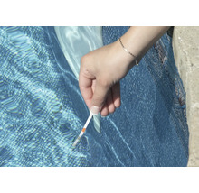Iemand test het zwembadwater met een teststrip