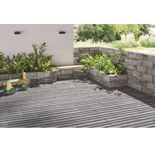 Terras met plantenbakken van stenen en houten speelgoed