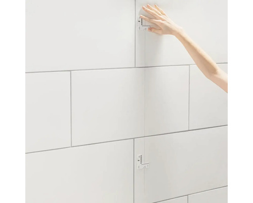 Tegelzetter die wandtegels legt met behulp van een tegelmal