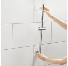 Installatie van een douchestang in een badkamer met witte tegels