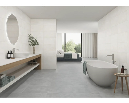 Lichte badkamer met bad, wastafel en spiegel