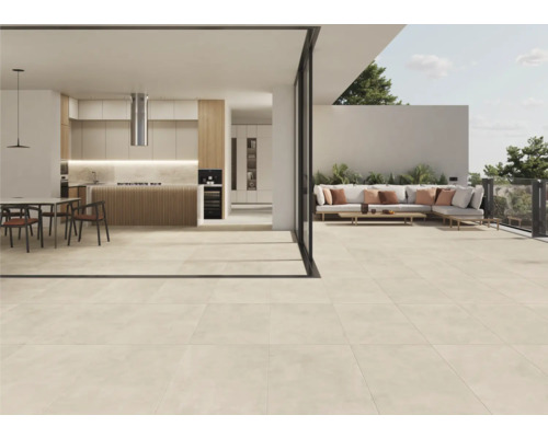 Lichte vloertegels verbinden de binnen- en buitenruimte van een huis.