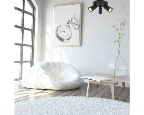 Lichte kamer met zitzak, vloerkleed, plafondlamp en wanddecoratie