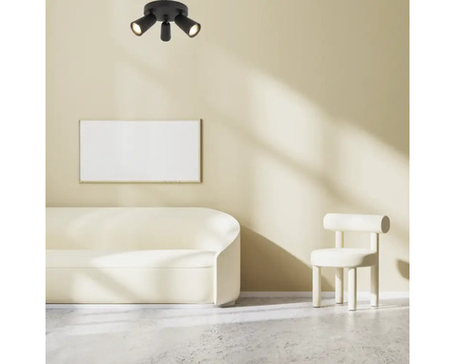 Plafondlamp met drie spots in een lichte woonkamer