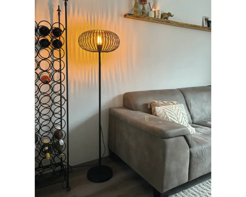 Staande lamp met draadlampenkap en wijnrek in de woonkamer