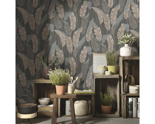 Decoratieve kamer met een behang met bladmotief en planten op houten kratten.