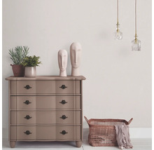 Kast met lades, decoratie en verlichting in een lichte ruimte