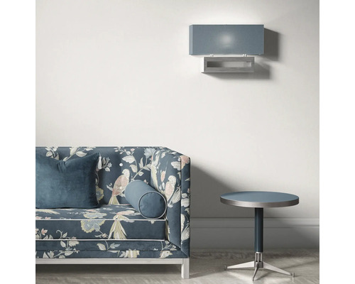 Scene met een bank met vogelmotief, een ronde bijzettafel en een wandlamp