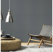 Modern interieur met fauteuil, kruk, lampen en grijze muur