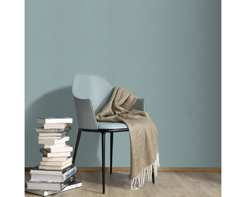 Scene met stoel, stapel boeken en deken tegen een muur