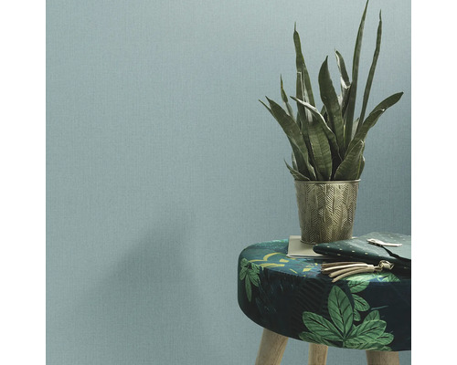 Behang in de woonkamer met plant en kruk.