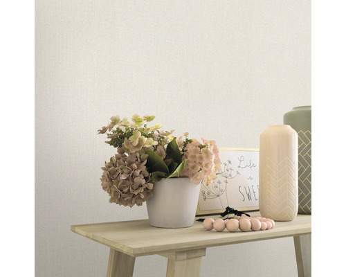 Decoratieve scène met behang, bloemen en vazen op een tafel.