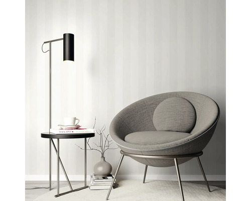 Scene met een fauteuil, een bijzettafel en een staande lamp.