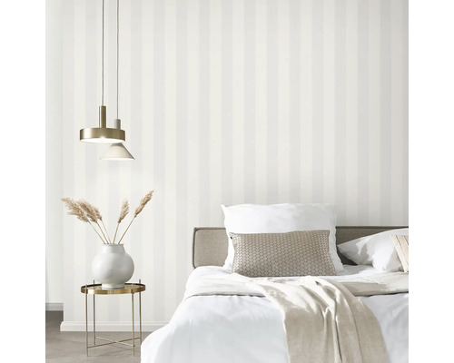 Slaapkamer met bed, lamp en gestreept behang