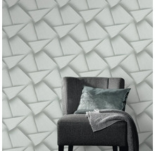 Decoratief behang met driedimensionaal driehoekpatroon en een fauteuil in de kamer.