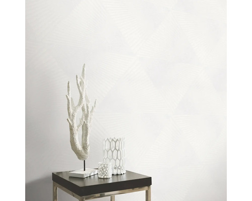 Decoratieve scène met koraalornament, kandelaars en geometrisch behang op een bijzettafel.