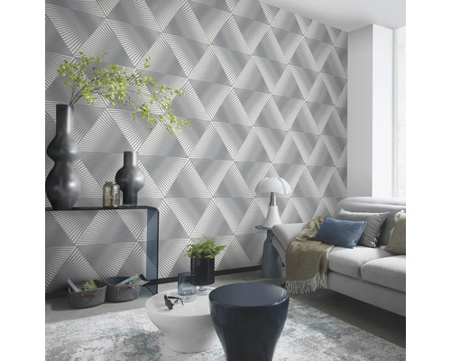 Woonkamer met driehoekig designbehang, bank, tafel en decoraties voor een moderne woonomgeving.