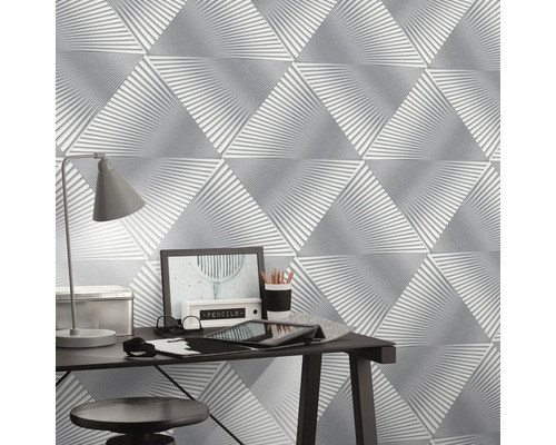 Close-up van een muur met driehoekig gestructureerd behang in een werkkamer.