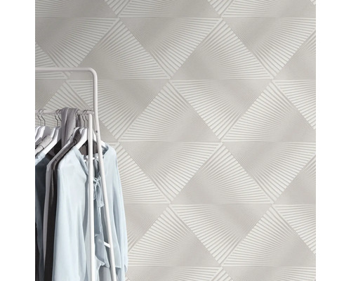 Driehoekige, witte wandtegels met abstract patroon en kledingrek