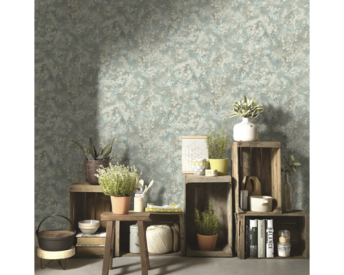 Woonkamer met bloemenbehang, houten kisten en decoratieve objecten.