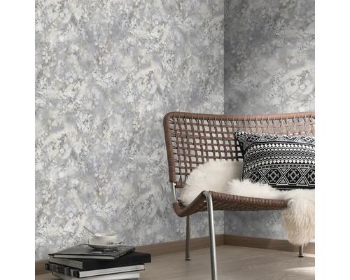 Decoratief behang met plantenmotief in een lichte kamer met stoel en accessoires.