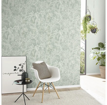 Woonkamer met een wand met een behang met plantenmotief, een stoel en decoratieve elementen.