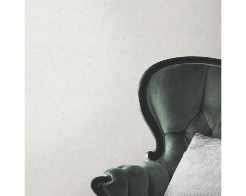 Detailopname van een groene fauteuil met kussen voor een muur