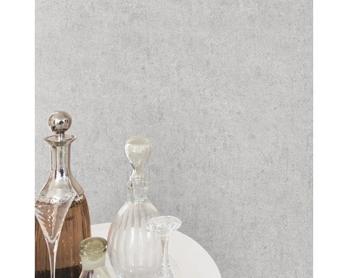 Close-up van een grijs vliesbehang met een fijne structuur op de muur