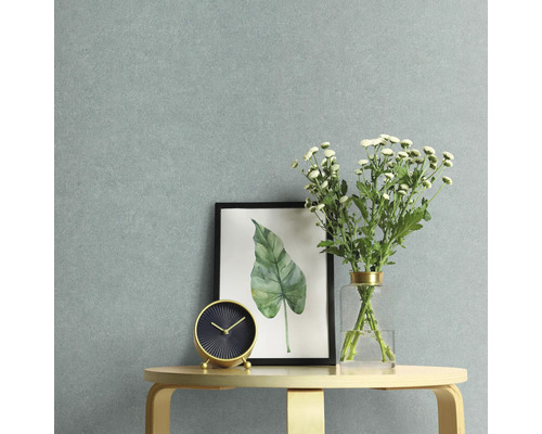 Close-up van een kamerdecoratie met een tafelklok, ingelijste afbeelding en bloemenvaas tegen een heldere muur