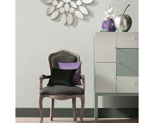 Woonkamer met stoel, kussens, dressoir en decoratie