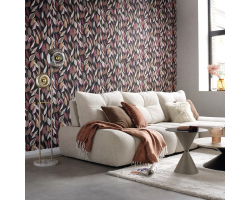 Woonkamer met behang met patroon, bank, staande lamp en salontafels.